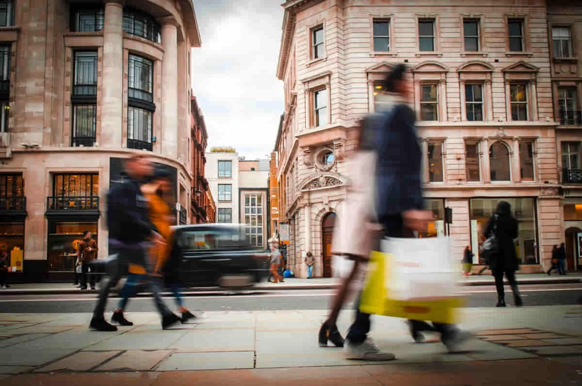 Shopper carrying bags through a busy city street