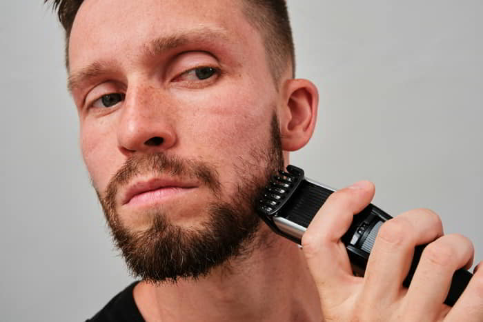 Man trimming his beard with an electric trimmer